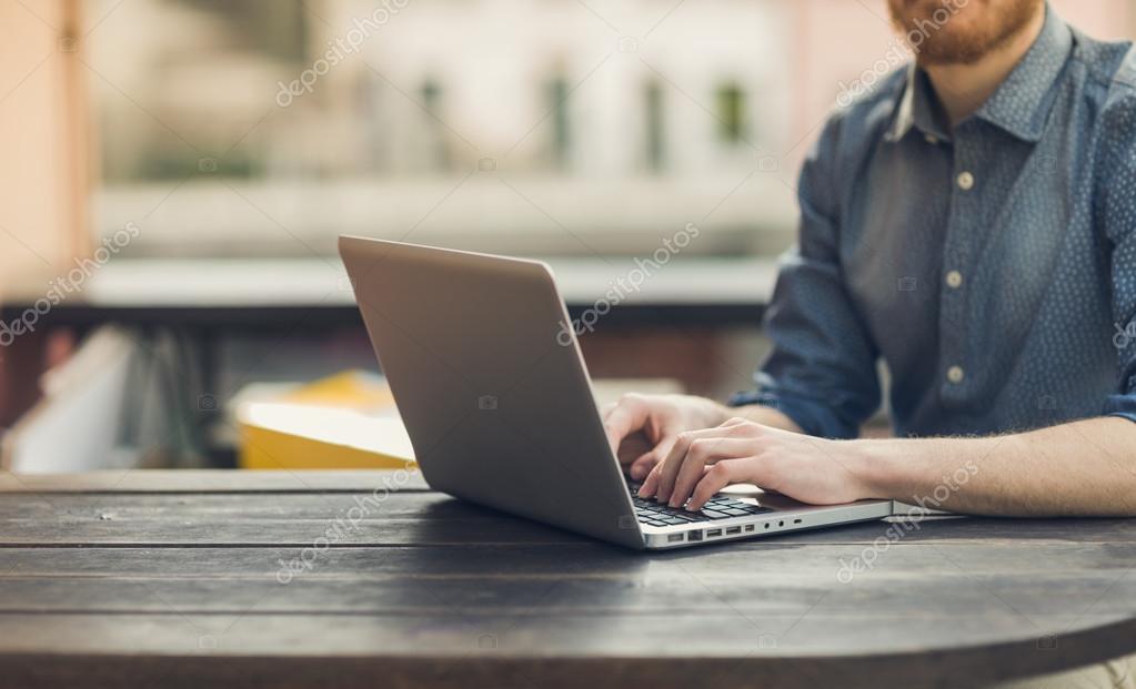 Man using a laptop on an outdoor table