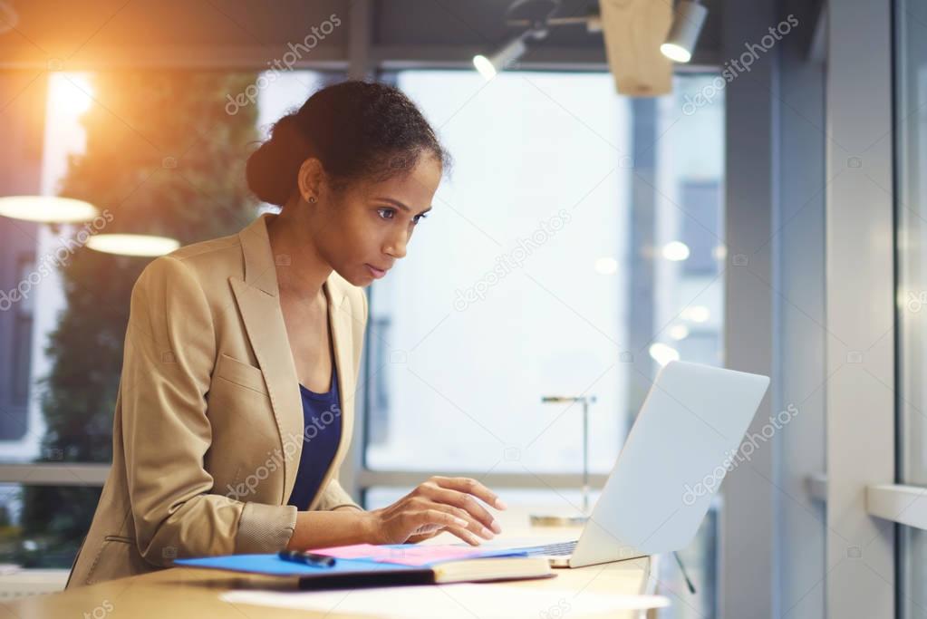 Mindful professional female executive making business report about increasing income and sales