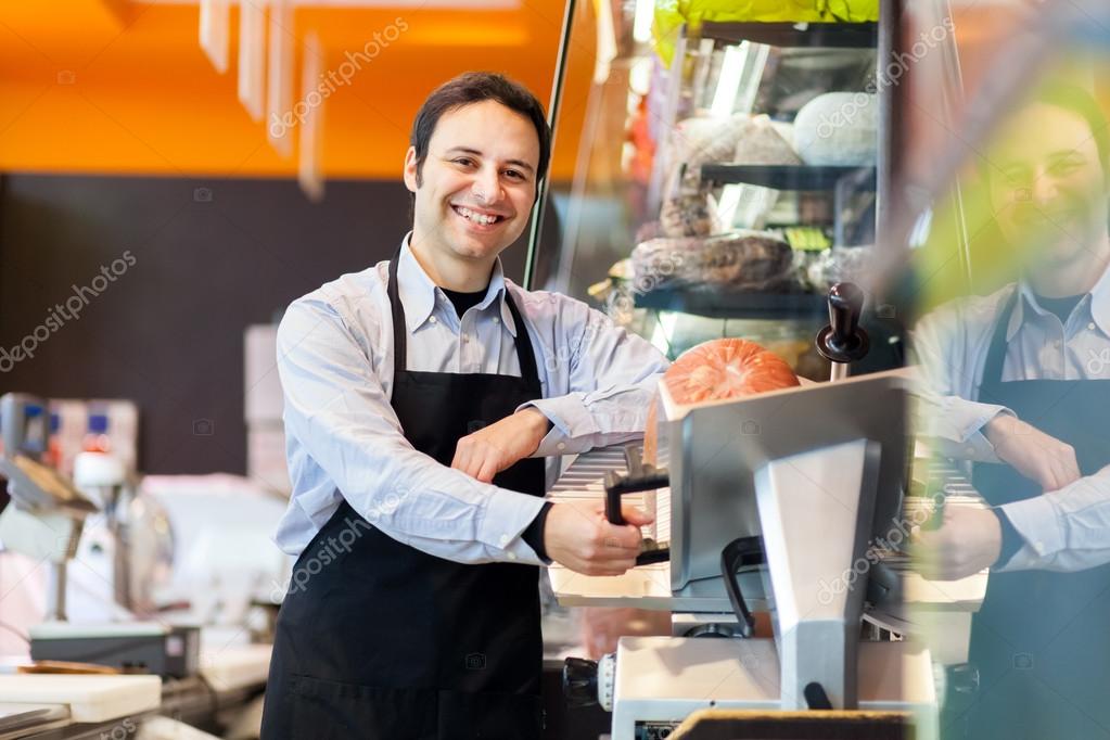 Shopkeeper cutting ham