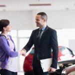 Smiling salesman shaking the hand of a woman