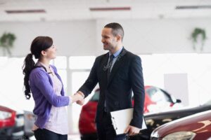 Smiling salesman shaking the hand of a woman