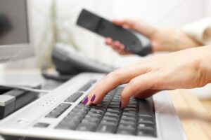 Businesswoman is typing on keyboard and answer the call. custome