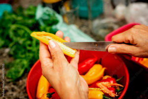 Mãos femininas cortando uma pimenta