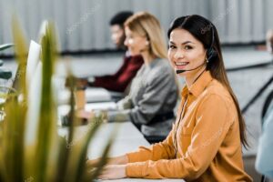 multicultural call center operators with headsets at workpalce in office