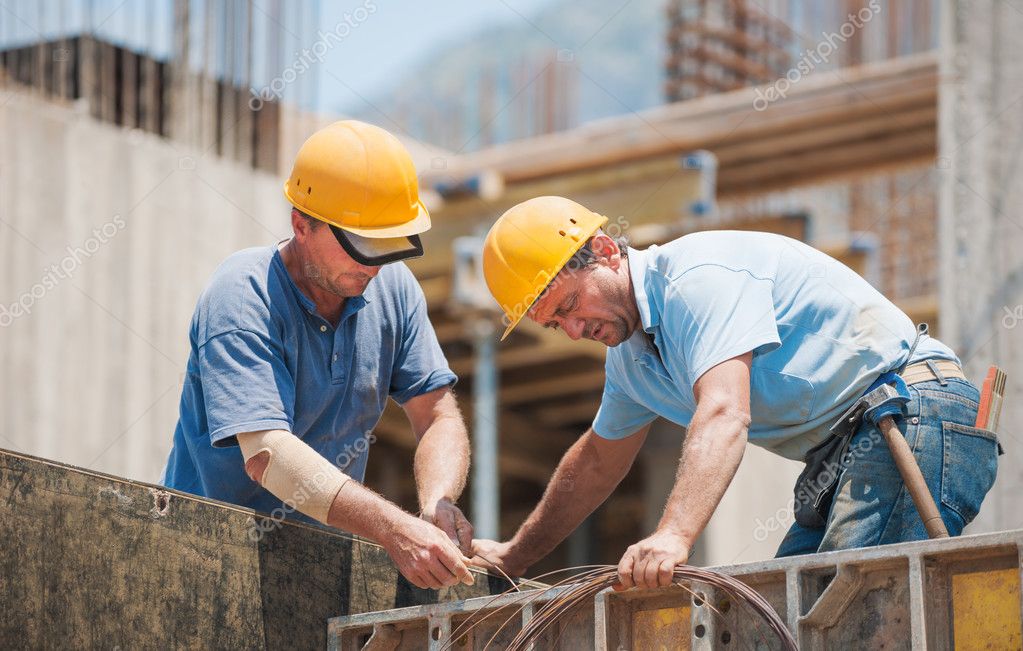 Construction workers working on cement formwork frames