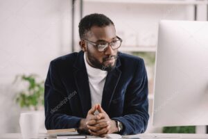 focused african american businessman working with computer in office