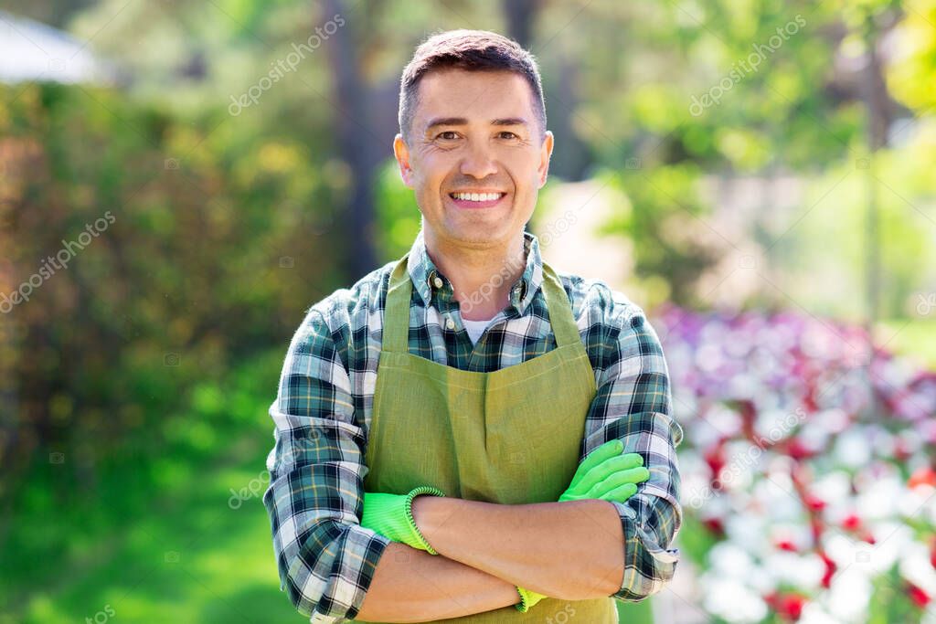 happy man in apron at summer garden