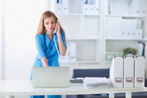 Medical doctor woman with computer and telephone.