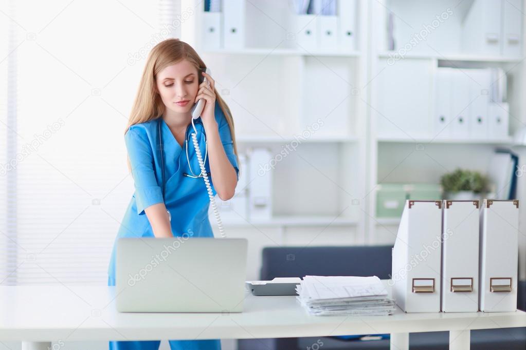 Medical doctor woman with computer and telephone.