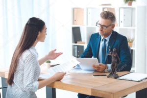 lawyer and client holding papers and discussing contract in office