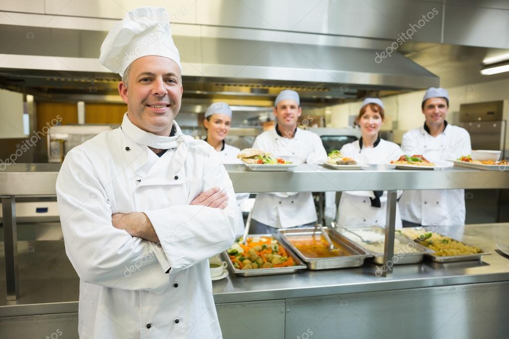 Proud mature head chef posing in a modern kitchen